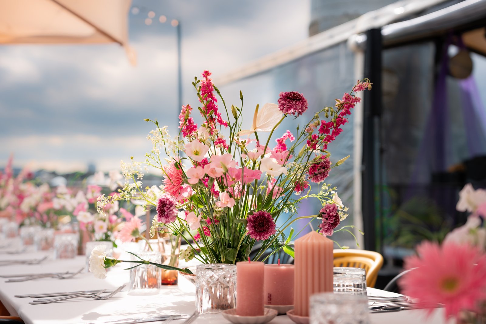 Wedding reception table pink flower decor in vilnius oldtown on a rooftop