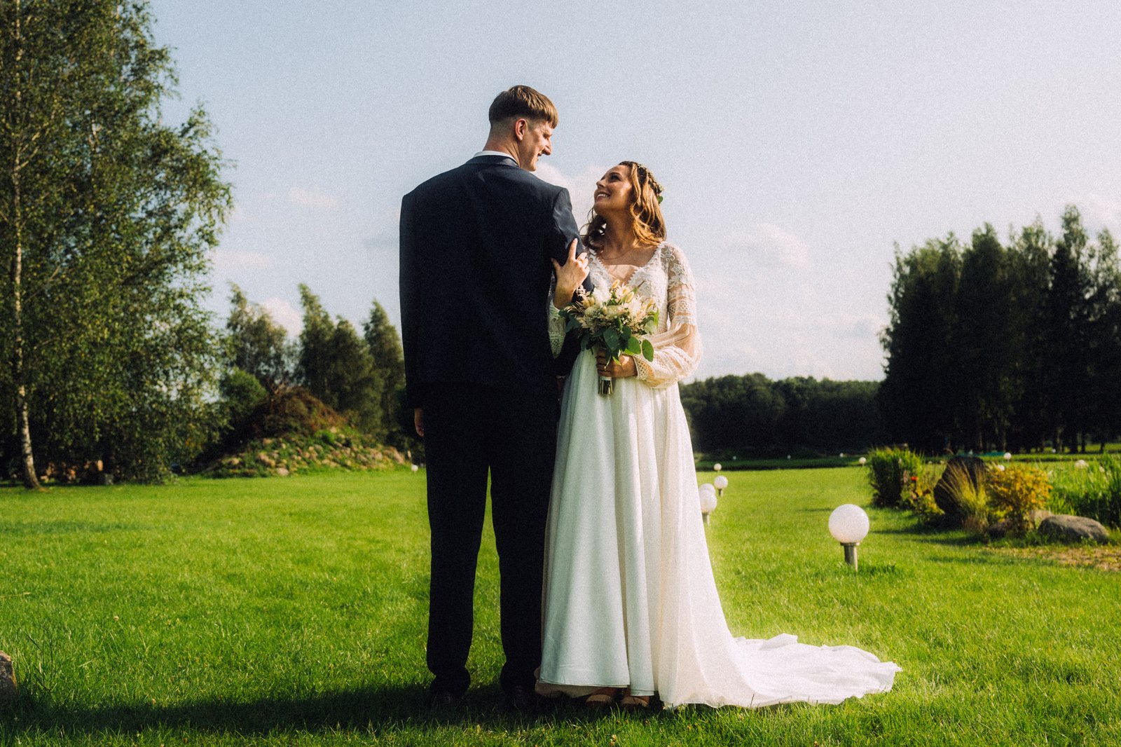 Wedding couple photo in rural grass frield with sunshine in lithuania